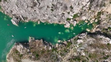 Yeşil kanyonda yüzen ve güneşin tadını çıkaran insanların olduğu manzaralı bir kürek çekme gezisi..