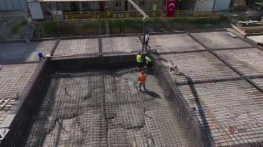 Bir inşaat ekibi yüksek katlı bir konut inşaatında çalışıyor, verimli bir şekilde çalışıyor..