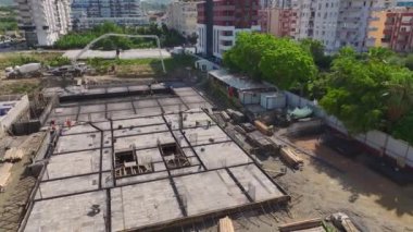 İşçilerin yüksek binalar inşa ettiği yoğun bir inşaat alanı..