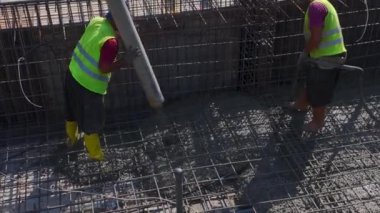 İşçilerin bir iskan binası inşa ettikleri yoğun bir inşaat alanı.