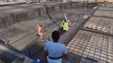 İşçiler hareketli bir inşaat sahasına yüksek bir konut inşa etmekle meşguller..