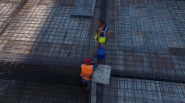 İnşaat işçileri yeni yüksek binalar inşa etmek için çok çalışıyorlar..