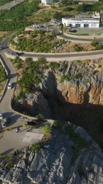 Dikey Video: Akdeniz dalgaları uzaktaki dağlar yakınlarında çarpışıyor.