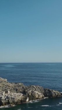 Dikey Video: Pebbled plajı güneşin altında berrak Akdeniz sularıyla buluşuyor.