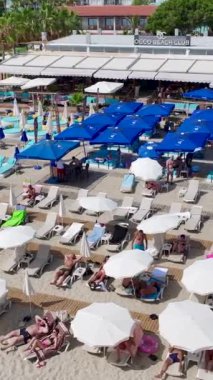 Dikey Video: Yoğun bir plaj kulübü eğlenceli aktiviteler ve rahatlama sunuyor.