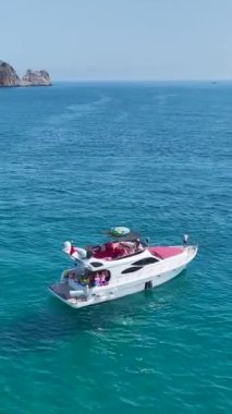 Dikey Video: Turistler kıyıya yakın yatların kıyı manzaralarına hayranlar.