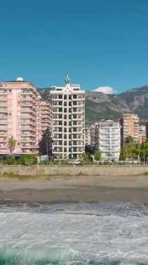 Kıyı şeridi boyunca beyaz cepheli ve çatılı modern evler inşa ediliyor..