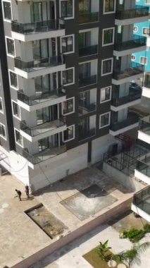Büyük bir inşaat sahasında kalifiye işçiler ve ev inşa eden makineler yer alıyor.