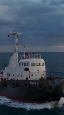 Römorkör, canlı bir günbatımı ve büyük bir gökkuşağının altında limana doğru yol alıyor..