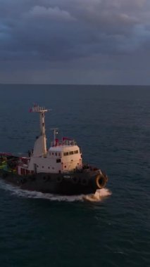 Limana yakın bir römorkör Parlak bir günbatımı ve cesur bir gökkuşağının altında.