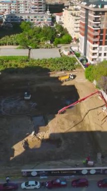 İşçiler ve makineler sağlam temeller oluşturmak için birlikte çalışırlar.