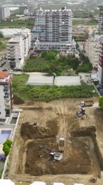 İşçiler ve makineler canlı bir inşaat sahasında yeni projeler şekillendiriyor.