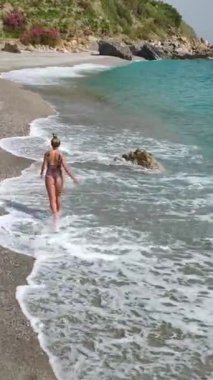 Şık bir manken mavi okyanus manzaralı bir yatta güven içinde poz verir..