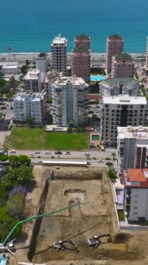 İşçiler deniz kenarındaki canlı bir şantiyeye beton döküyorlar..