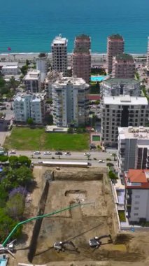 Deniz manzaralı canlı bir şantiyeye ekipler beton döker.