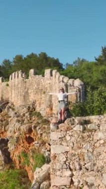 Dikey Video: Ardında Açık Mavi Akdeniz Suları Olan Bir Uçurumda Modellik Yapıyor