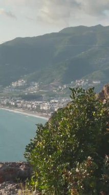 Güzel bir model, çarpıcı deniz manzaralı yüksek bir uçurumda zarif pozlar verir..