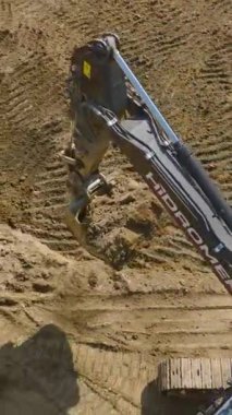 Makineler ve işçiler inşaat projesinin sağlam bir zeminde başlamasını sağlıyorlar.