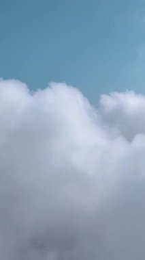 Yumuşak bulutların berrak gökyüzüne karışıp sakin bir hava yarattığı huzurlu bir manzara..