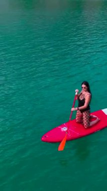 Kürekçilerin kıyı şeridindeki canlı enerjinin tadını çıkarmasını izleyin..