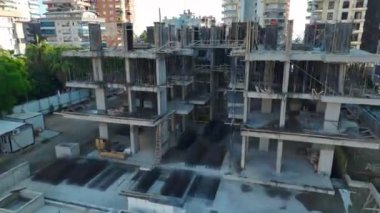 İşçiler her katta gözle görülür gelişmeler olan lüks bir bina inşa ediyorlar..