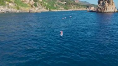 İnsanların yüzdüğü, güneşlendiği ve kürek çektiği berrak suları olan manzaralı bir sahil..