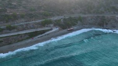 Fırtınalı denizden gelen dalgalar şafak vakti kayalara çarpar ve çarpıcı deniz dokuları görünür..