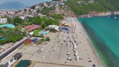 Akdeniz 'de su sporlarından ve aktivitelerden keyif alan insanların olduğu canlı beyaz bir sahil..