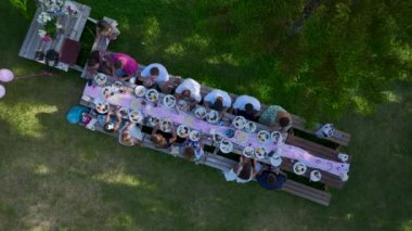 Bereketli bir bahçede neşeli bir piknik. Lezzetli yemekler ve mutlu arkadaşlarla dolu..