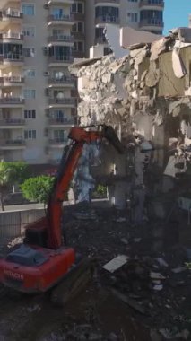 Yeniden geliştirme için beton duvarları delen kazıcı.