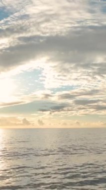 Huzurlu günbatımı sahnesi, dokulu bulutlar ve ışıldayan suyla.