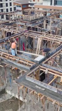 İnşaat projesinde malzeme kaldırma işiyle meşgul işçiler..