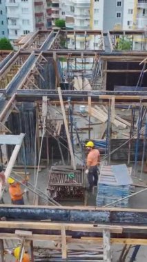 İşçiler vinç kullanırken yüksek tempolu inşaat işi.