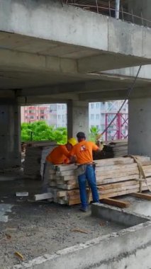 Çalışan işçiler vinç ve araç gereç taşımakla meşguller.