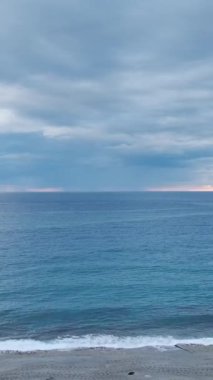 Sakin okyanus, mavi bir günbatımının altında, suların yüzeyinde yumuşak dokularla parlar..