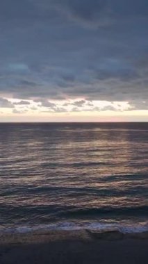 Akdeniz üzerinde parlak renkler ve desenli dalgalarla baş döndürücü bir gün batımı..