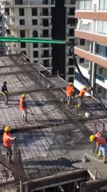 Yüksek katlı bir binanın tabanına beton dökülüyor.