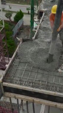 İşçiler dinamik bir alana betonla temeller atıyorlar.