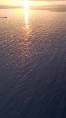 Gün batımı, açık denizlerden limana dönen bir tekne gibi parlıyor..