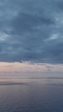 Akdeniz 'de bulutlu bir gökyüzünün altında gün batımı yansımaları.