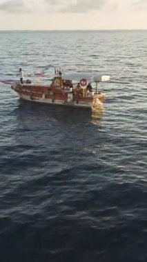 Büyülü tekne ve günbatımı manzaralı sakin denizler.