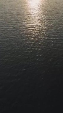 Işıl ışıl güneş ışığı ve dalgalanmalarla deniz desenlerinin havadan görünüşü.