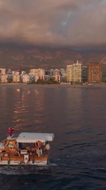 Parlayan bir şehir ve sakin denizlerle sakin bir gün batımı anı.