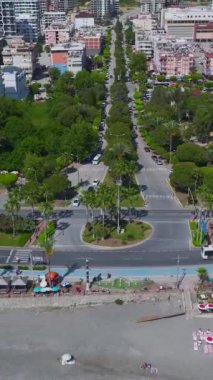 Arabalar çarpıcı manzarası olan manzaralı bir sahil yolunda yol alırlar..