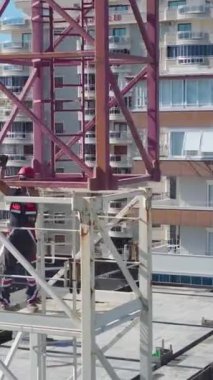 Yetenekli işçiler, adım adım büyük bir vinç monte ediyorlar..