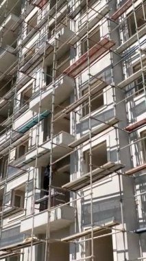 İşçiler inşaat alanındaki iskele ön panellerini tamir ediyorlar..