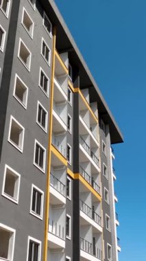 İşçiler bir inşaat projesinde iskele üzerine ön panel kuruyorlar.