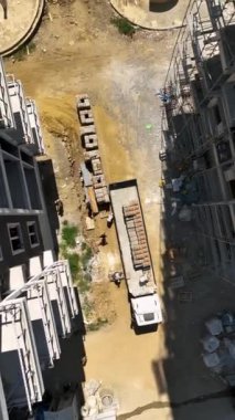 İşçiler, yeni bir inşaat sahasındaki iskele panellerini tamir ediyorlar.
