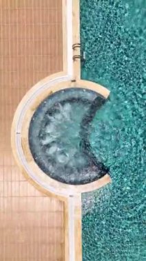 Sakin bir havuz, temiz su ve rahatlatıcı bir ortamda kaynayan bir jakuzi..