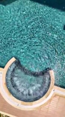 Jakuzili ve kristal berraklığında su kaynayan sakin mavi bir havuz..